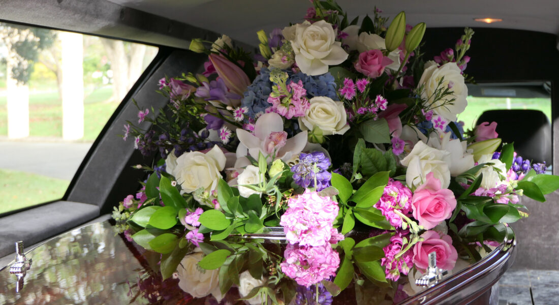closeup shot of a funeral casket in a hearse or chapel or burial at cemetery